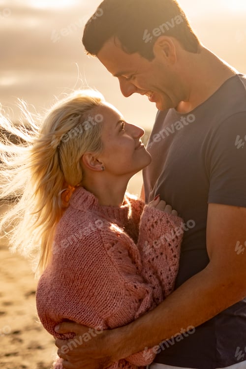 Preview: People in love and golden sunset outdoor - man and woman couple hug and look