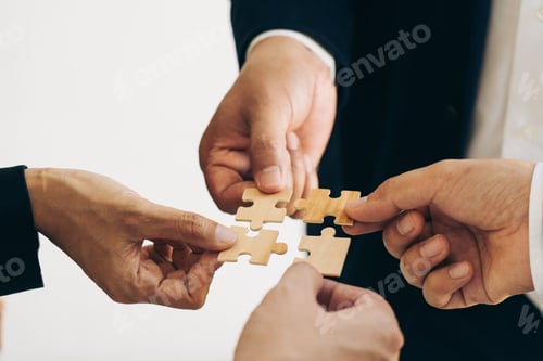 Preview: The concept of teamwork and partnership. Businessman's hands putting together puzzle