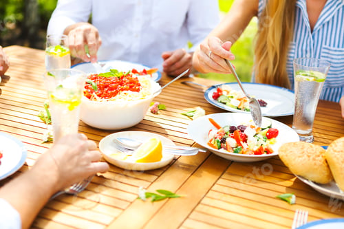 Preview: Family dinner variety of Italian dishes on wooden table in the garden