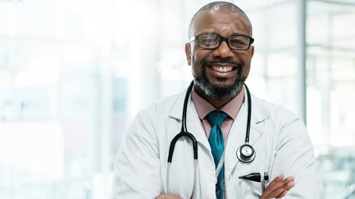 Preview: Black man, doctor and happy with arms crossed at hospital for medical service in Uganda. Mature per