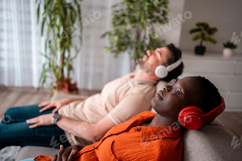 Preview: Two friends relaxing at home while listening to music in a cozy living room setting
