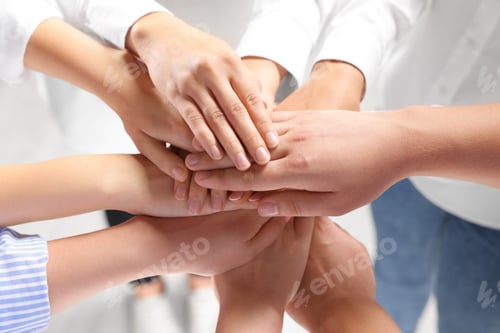 Preview: Group of people holding hands together indoors, closeup. Unity concept