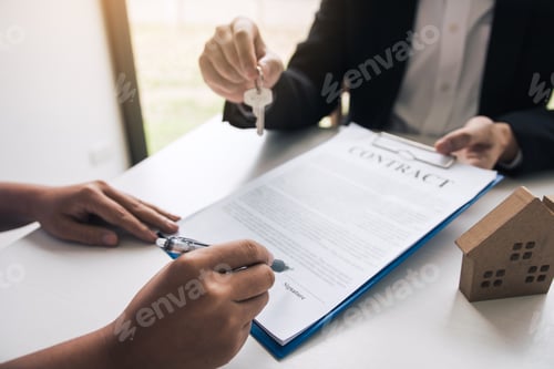 Preview: Hand of real estate agent passes the key to new homeowners in office with buyer house concept.