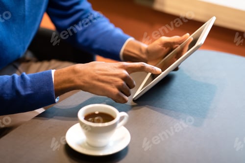 Preview: Black man sitting in coffee shop drinking cup of coffee