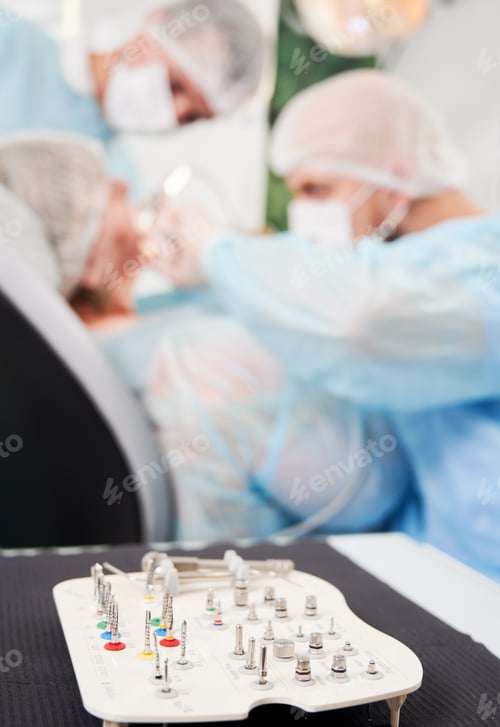 Preview: Dentist and his assistant working with a patient in a dentist chair in dentist office