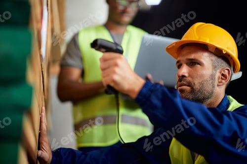 Preview: Close-up of worker scanning labels while working at wood warehouse.