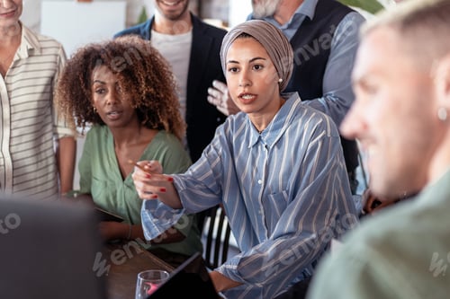 Preview: Multiethnic group of business colleagues problem solving around the computer screen gesturing