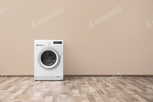 Preview: Modern washing machine with laundry near color wall, space for text