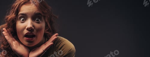 Preview: Portrait of young surprised redhead woman, studio shoot.