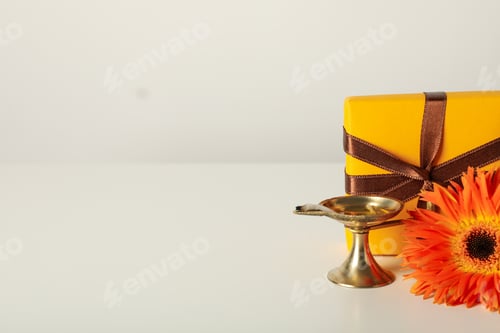 Preview: Copper lamp, gift box and flower on light background, space for text