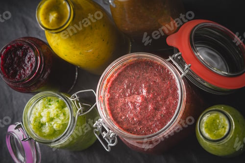 Preview: Jars and bottles with different smoothie on the dark stone table horizontal