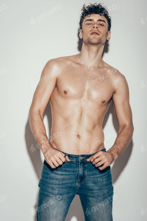 Preview: handsome sexy shirtless man in jeans posing on grey