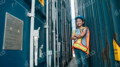 Preview: Child girl safety container logistics proud girl in safety vest stand between cargo container