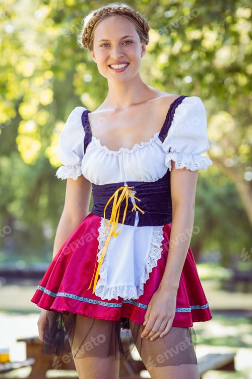 Preview: Pretty oktoberfest blonde smiling in the park on a sunny day
