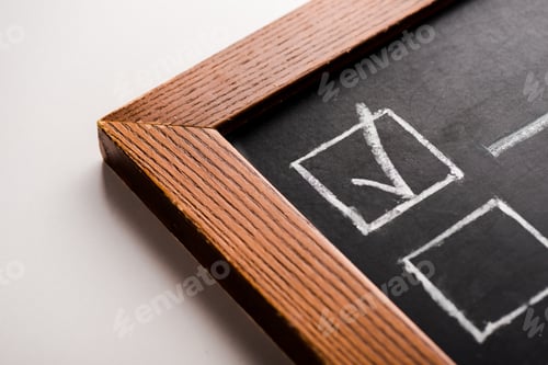 Preview: close up of chalk board with white tick on white