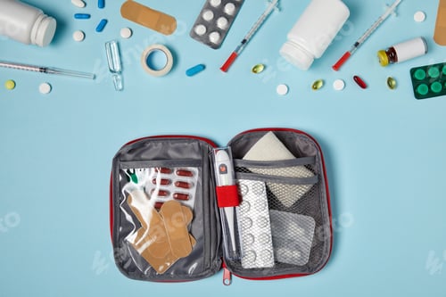 Preview: top view of opened first aid kit bag on blue tabletop