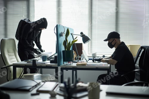 Preview: Young Male Burglars Wearing Masks Hacking into Laptops in Corporate Office