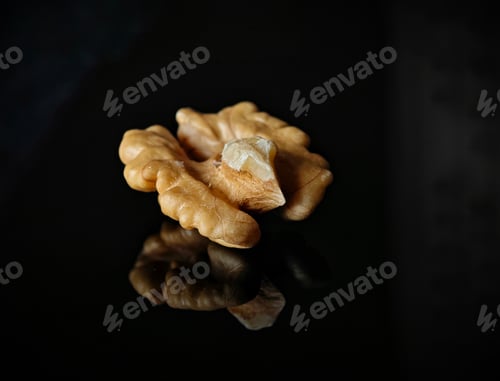 Preview: some walnuts are placed on the black surface and a shadow