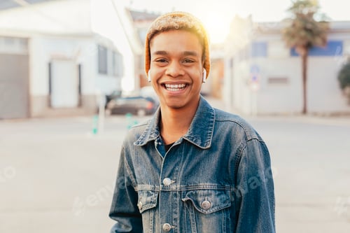 Preview: Young modern afro latin boy listens podcast with earphones outdoors