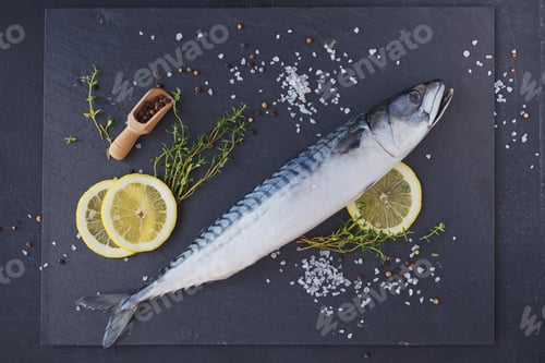Preview: Fresh raw fish mackerel and ingredients for cooking on a dark background in a rustic style.