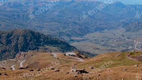 Preview: View of the mountainous area. Action. Mountain ranges with forests and built houses.