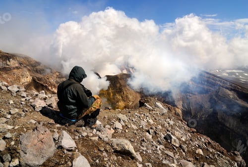 Preview: Man on edge of Gorely Volcano crater, looking at gas and steam plume, Kamchatka Peninsula, Russia