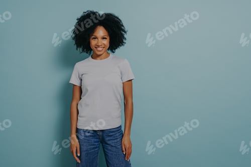 Preview: Delighted young african female posing isolated over blue background with pleasant smile