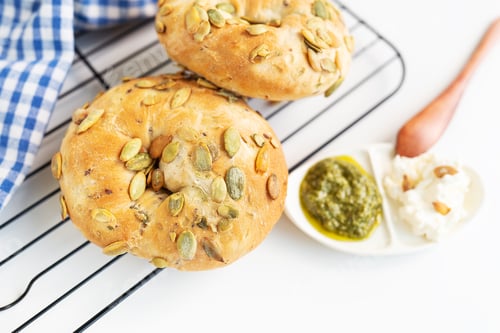 Preview: Fresh pumpkin seed bagel bread with pesto and cream cheese on a grill. Delicious snack.