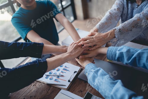 Preview: Young Asian business people shaking hands and working together as a team and having unity