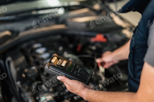 Preview: Close-up of auto mechanic using car diagnostic tool at service workshop.