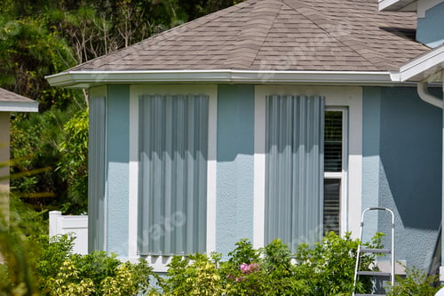 Preview: Boarded up windows with steel storm shutters for hurricane protection of residential house