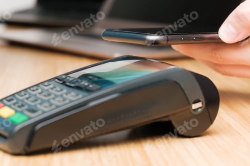 Preview: Man uses wireless terminal contactless payment with smartphone