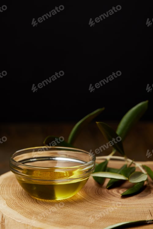 Preview: olive oil in bowl with branch on wooden board