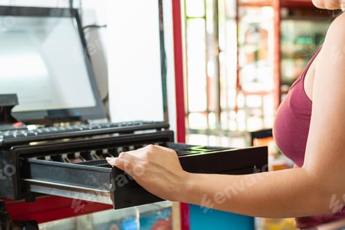 Preview: latina woman opening the cash register of her business to see how much money there is