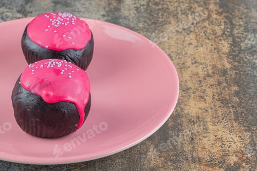 Preview: Two sweet chocolate doughnuts with pink frosting and sprinkles