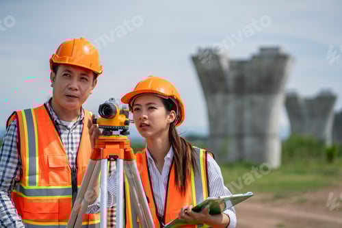 Visualização: A equipe de pesquisa está trabalhando com um teodolito e planos de construção de estradas.