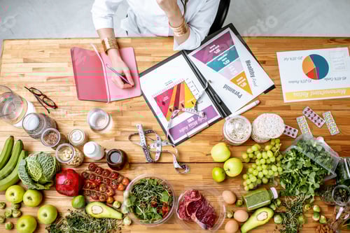 Preview: Writing a diet plan on the table full of healthy food
