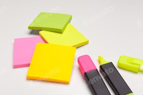 Preview: Sticky notes with markers, colored pens, paper clips laying on a table
