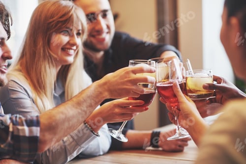 Preview: Hands of people with glasses of whiskey or wine, celebrating and toasting in honor of the wedding or
