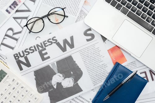 Preview: top view of eyeglasses, pen and notebook and laptop on newspapers