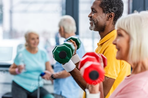 Preview: selective focus of interracial mature couple doing exercise with dumbbells at gym
