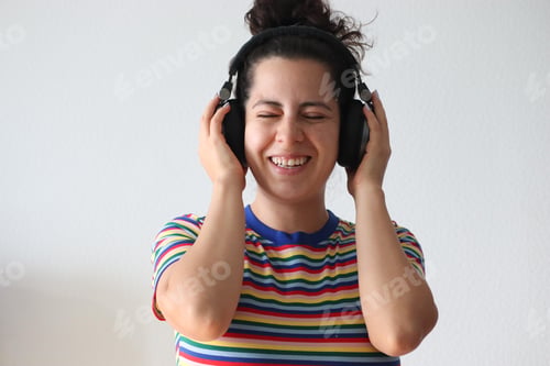 Preview: Happy Woman Listening to Music with Headphones Indoors