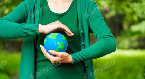 Preview: Forest conservationist holds small globe in hands,symbolizing global responsibility for protecting