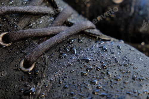 Preview: close-up details waterproof men's black boots. Drops of rain on suede shoes.