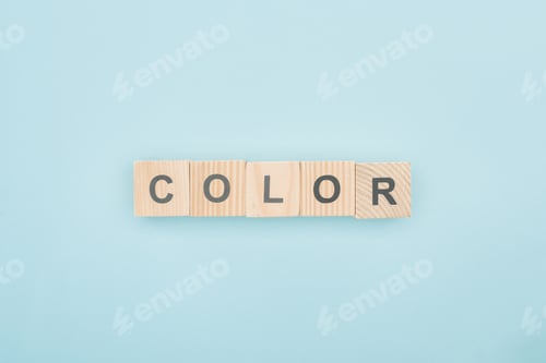 Preview: top view of color lettering made of wooden cubes on blue background