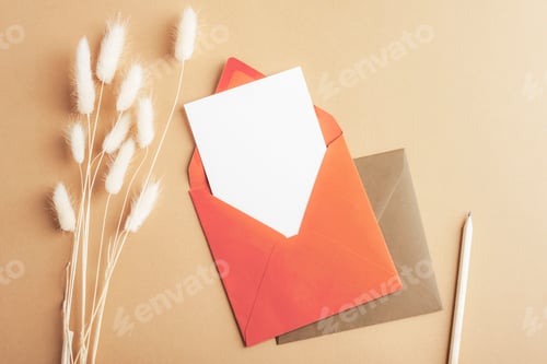 Preview: Red envelope with blank card, pencil and bunny tails grass Lagurus Ovatus flowers on brown
