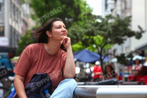 Preview: Daydreaming Woman Sitting on Bench on City Street