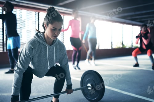 Preview: Fit healthy woman lifting a weight barbell