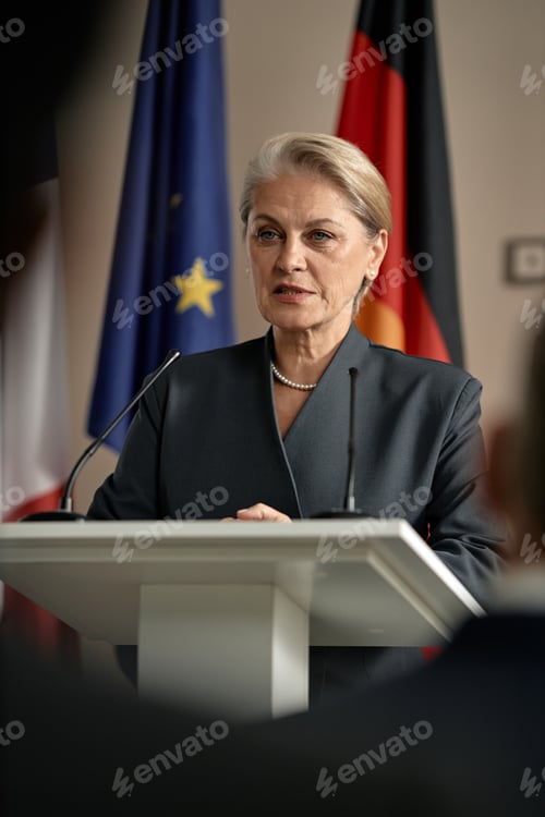 Preview: Senior Caucasian Woman Speaking at Podium during Political Press Conference