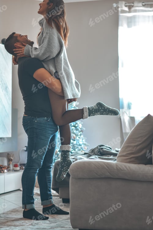Preview: Man Holding Woman Indoors in a Joyful Embrace